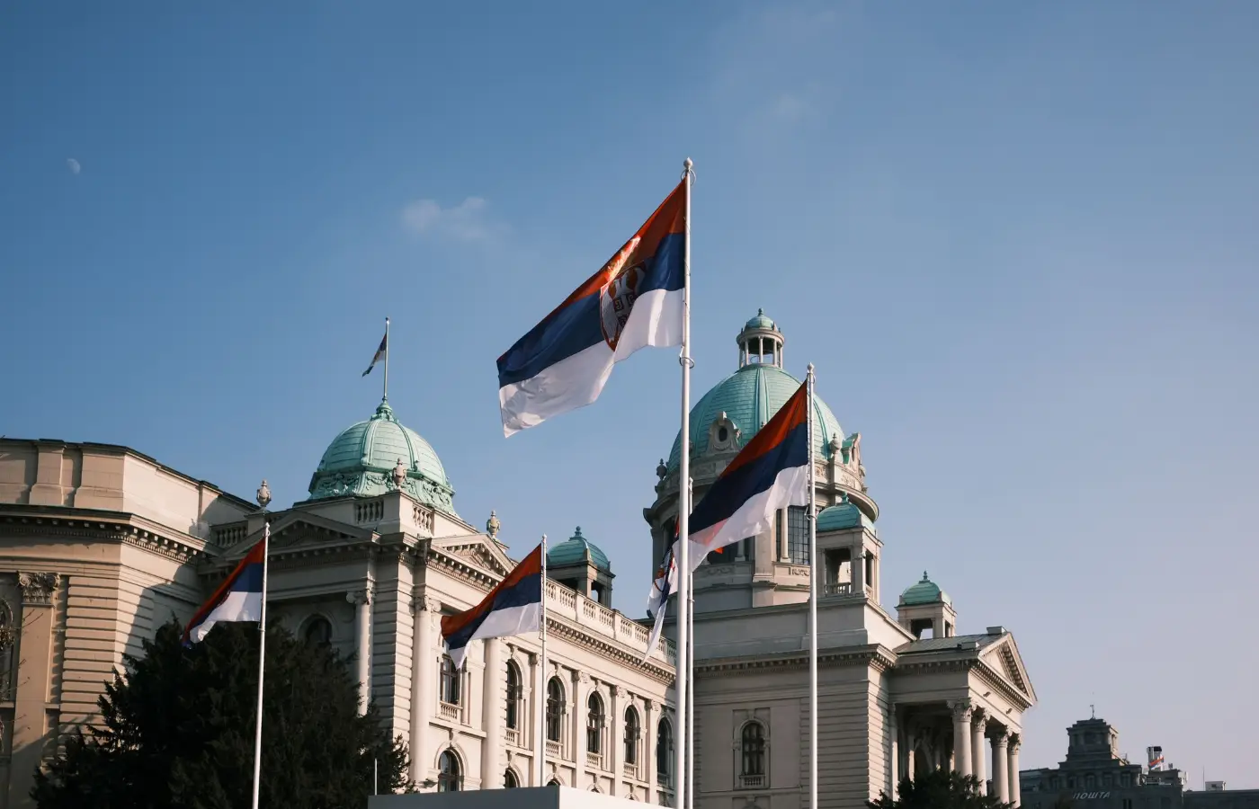 National Assembly of Serbia in Belgrade with Serbian flags flying, the country's parliament and a central European institution